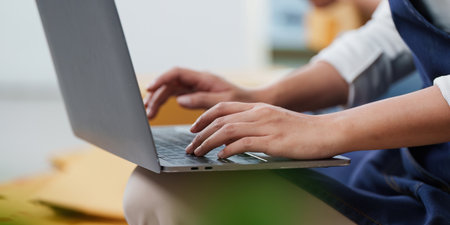 Remote Work. Individual typing on laptop, focused on digital tasks.