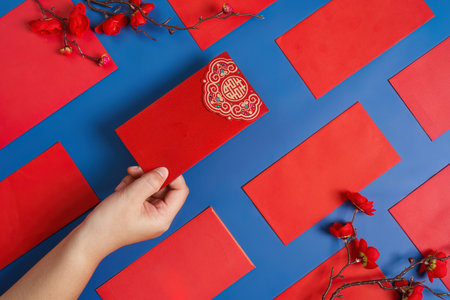 Chinese New Year celebration with red envelopes and oranges on blue backgroundの写真素材