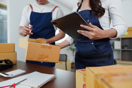 E-commerce. Team packing orders in a modern workspace.の写真素材