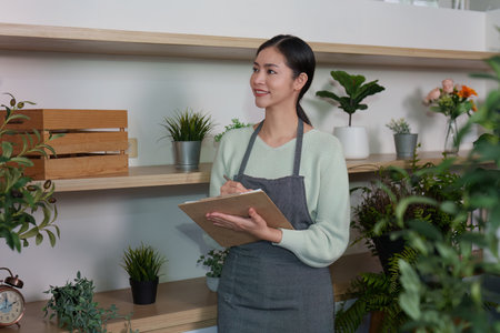 Plant Care. Smiling woman documenting plants in a stylish indoor garden.