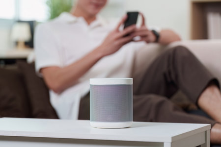 Smart Technology. A man using voice assistant with smart speaker at home.の写真素材