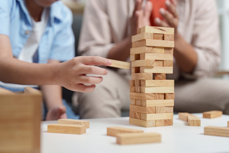 Family Life: Child playing Jenga with father in a cozy living roomの写真素材