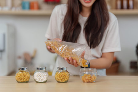 Zero Waste. Woman organizing dry food in glass jars for sustainability.