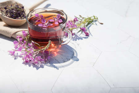 Herbal tea from fermented kipreya leaves in a glass Cup on a light background, the brew lies in a...