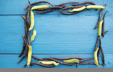 Pea and bean pods lie on a wooden background in the form of a frame-a source of vegetable protein....