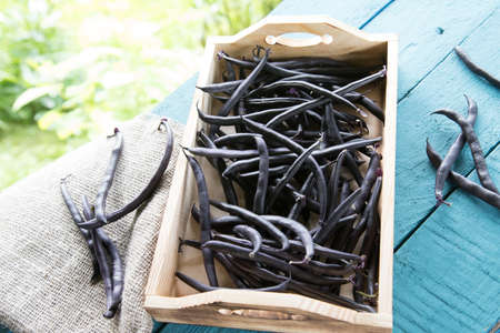 String beans lie on a wooden tray on a wooden background. The concept of healthy eating.Horizontal...