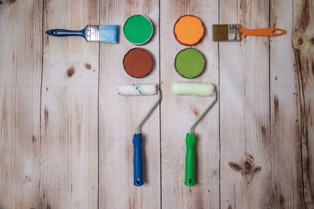 The concept of DIY repair. Paints and brushes on a wooden background. Horizontal orientationの写真素材