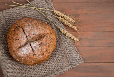 Bread with home-baked cereals on a napkin with spikelets. Horizontal orientation.Place for a copy...