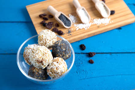 Homemade energy balls made from dried fruits, nuts, granola with sesame, almonds and poppy seeds on...