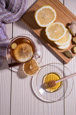 Warming vitamin tea with lemon and ginger in a glass Cup, white background. Vertical orientation.Flat Layの写真素材