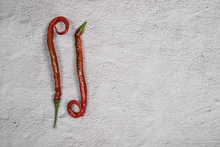 Two oddly shaped hot peppers. Horizontal orientation. Place for a copy spaceの写真素材