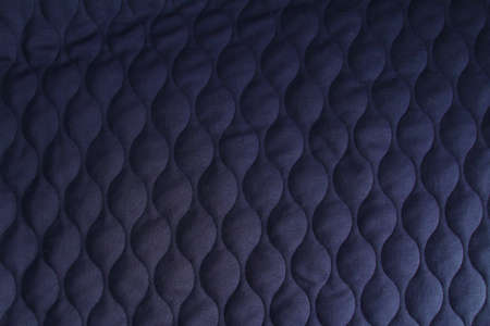 Fashionable quilted fabric in dark blue color. Abstract dark blue background.