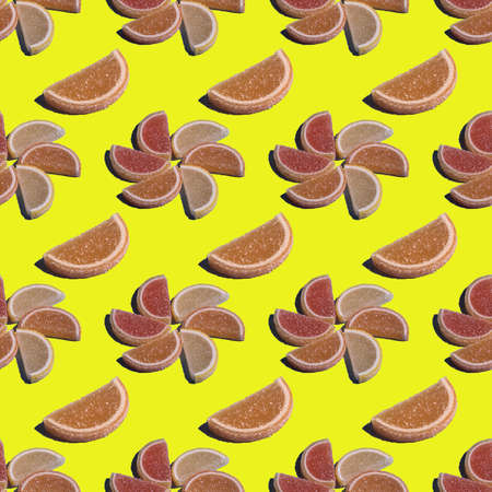 A decorative seamless candy pattern of marmalade in the form of citrus slices is laid out in the...