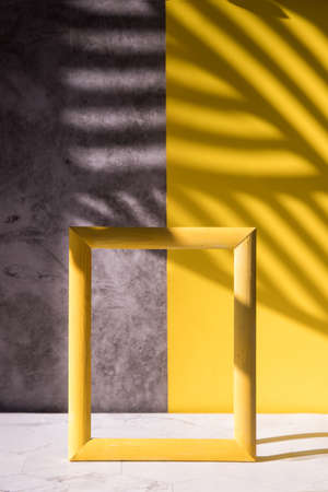 Abstract shadows on a gray-yellow background for the sale of a cosmetic product, a cosmetic showcase in a minimalist style.の写真素材