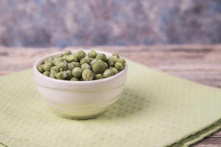 Frozen peas in a light plate on a light green napkin.の写真素材