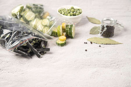 Bags of frozen vegetables string beans and zucchini as well as frozen green peas on a light...