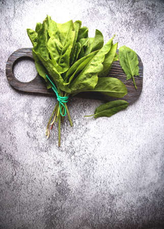 Garden sorrel spinach leaves lie on a wooden chopping board.の写真素材