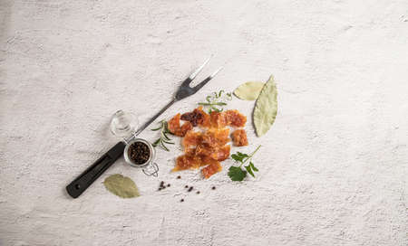 Top view of pieces of dried chicken meat with spicy herbs on a light table.の写真素材