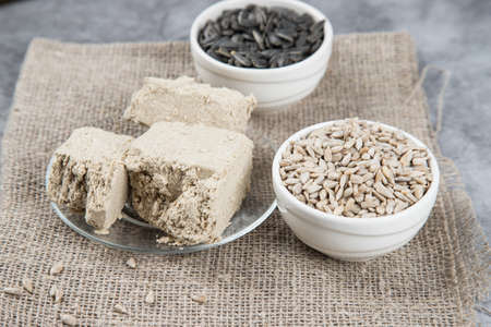 A plate with a dessert of halva made from sunflower seeds and sunflower seeds on a napkin.の写真素材