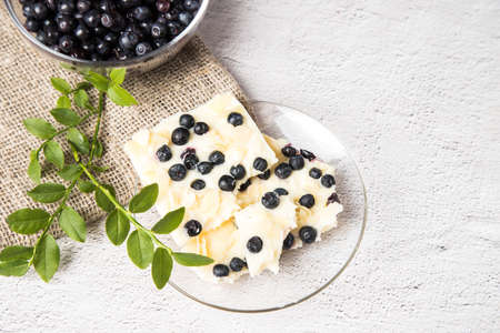 Handmade white chocolate with blueberries on a concrete background. Copy Space