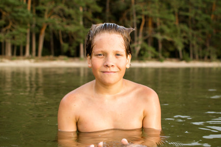 Camping weekend, teenage boy, lake and sandy shore.の写真素材