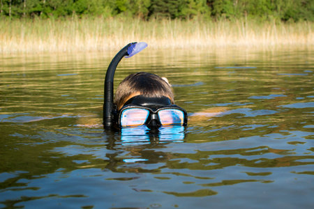 Weekends in nature with family, child in underwater diving maskの写真素材