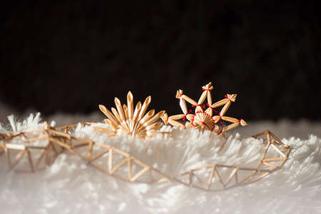 Background with traditional Christmas decorations- straw stars and string of reeds in sunlightの写真素材