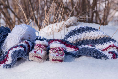 Knitted baby booties of warm wool in winter sunlight made with love