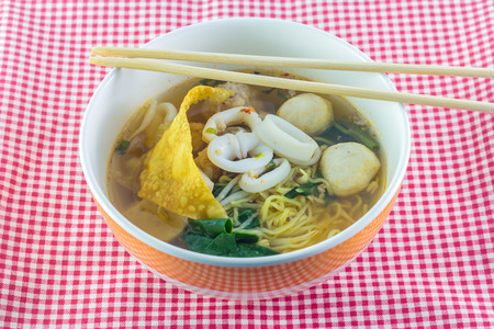 Close up Thai noodle with squid on blue canvas tablecloth. Thai cuisine