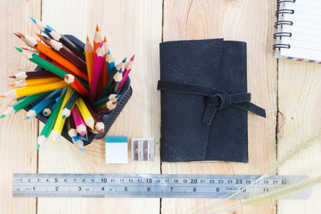 Note book and color pencils on wooden background - Vintage effect style pictures