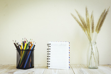 Color pencils and book on wooden background - Vintage effect style picturesの写真素材
