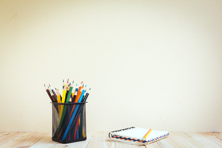 Color pencils and book on wooden background - Vintage effect style picturesの写真素材