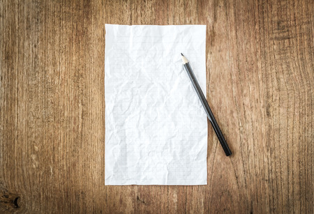 white paper with black pencil on wooden tableの写真素材
