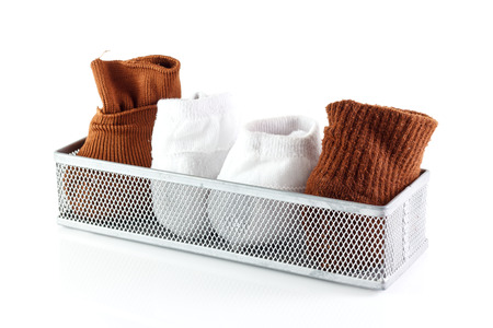 white and brown pair of sock in basket isolated on white backgroundの写真素材
