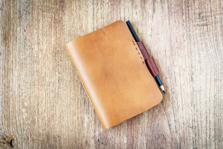brown Leather notebooks on wooden backgroundの写真素材