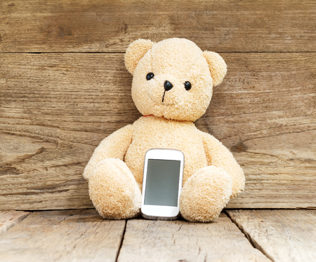 teddy bear with mobile phoneの写真素材