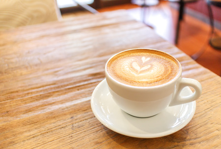Cup of coffee latte art on wood table, soft focusの写真素材