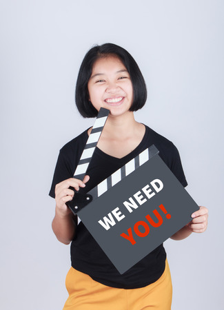 WE NEED YOU, message on slate film show by Asian girlの写真素材
