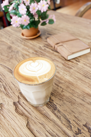 Cup of coffee latte art on wood tableの写真素材