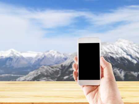 Hand using mobile smartphone in vertical position, blurred background - mockup templateの写真素材