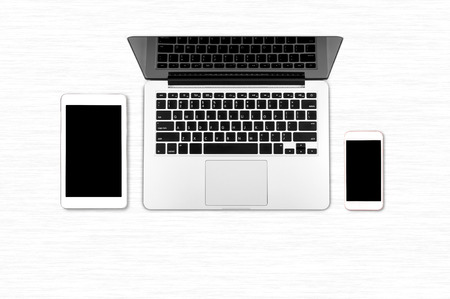 Top view laptop computer with mobile phone and tablet on office dask.Business template mock up for adding your textの写真素材