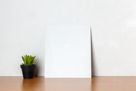 Blank white paper with little tree and coffee cup on a wooden deskの写真素材