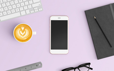 Modern office desk workplace with keyboard, coffee cup, notebook, pencil and smartphone copy space on color background. Top view. Flat lay style.の写真素材