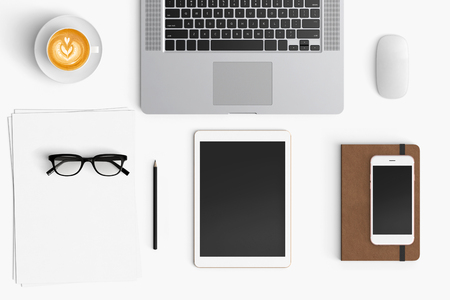 Modern workspace with coffee cup, smartphone, paper, notebook, tablet and laptop copy space on white color background. Top view. Flat lay style.の写真素材
