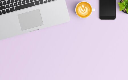 Modern workspace with coffee cup, smartphone, notebook and laptop copy space on purple color background. Top view. Flat lay style.の写真素材