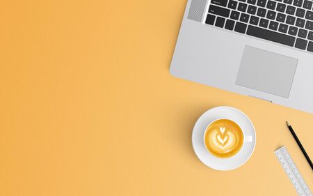 Modern workspace with coffee cup and laptop copy space on orange color background. Top view. Flat lay style.の写真素材