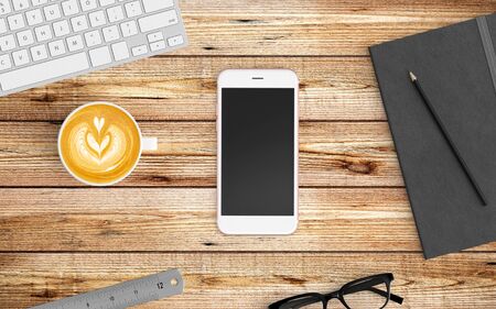 Modern workspace with coffee cup, notebook, tablet or smartphone and keyboard copy space on wood background. Top view. Flat lay style.の写真素材