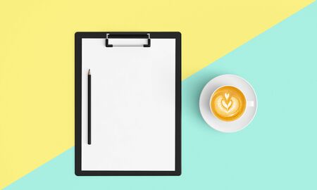 Modern workplace with notebook or laptop, coffee cup and smartphone copy space on color background. Top view. Flat lay style.の写真素材