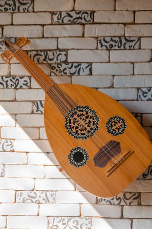 Traditional arabic musical instrument on brick wall.