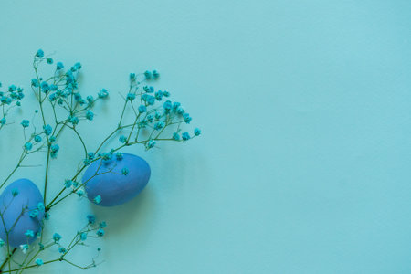 Easter composition of blue eggs and branch of flowers on blue backgroundの写真素材